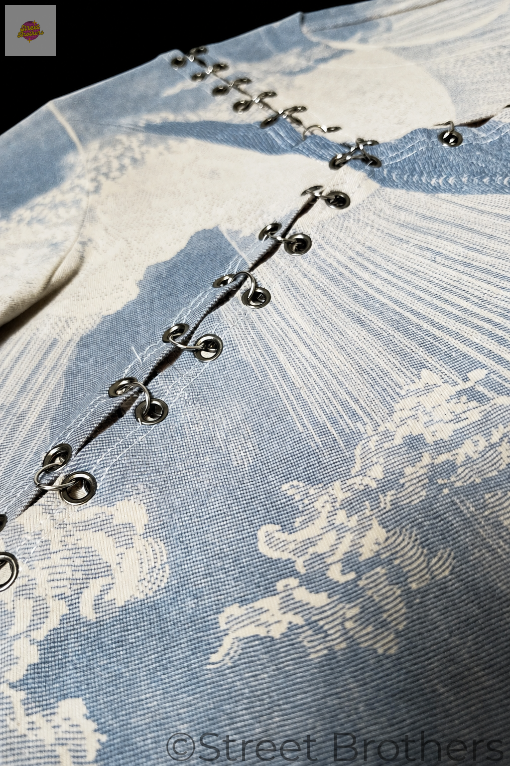 Détail du tissu imprimé et des œillets sur fond noir